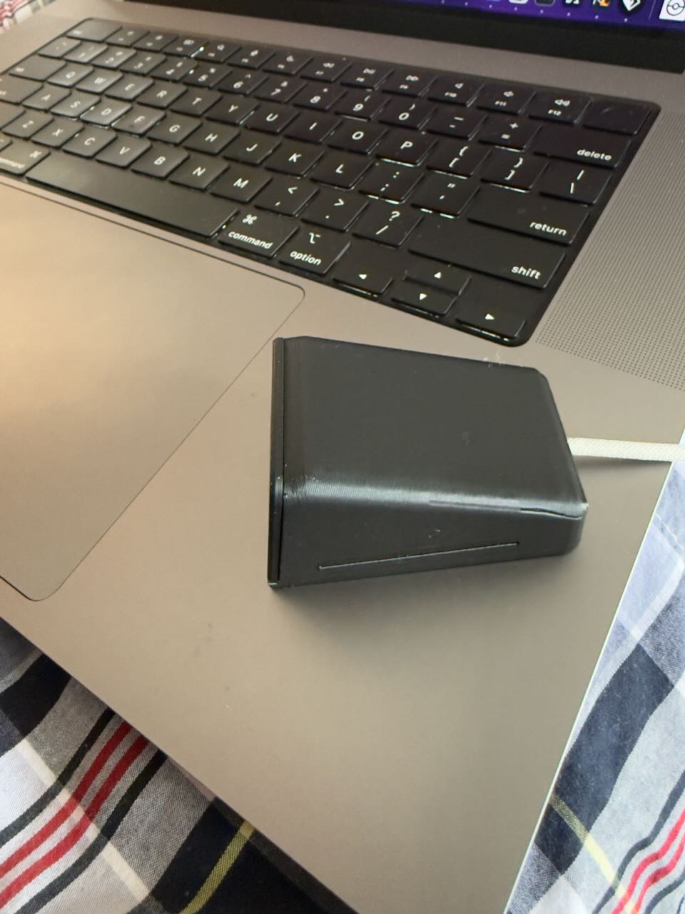 The XIAO clock enclosure closed, sitting on a laptop